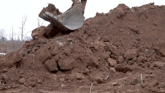 Closed up of a digger bucket picking up earth