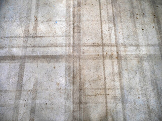 Concrete surface background. Old concrete floor. Gray background with dirty lines. Lines from cart wheels on concrete. Cement floor background. Wall texture with spots and cracks. Gray pattern