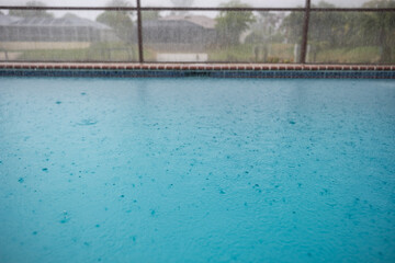 Fototapeta na wymiar Regentropfen auf der Wasseroberfläche eines Pools