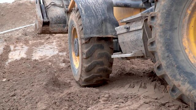 Large yellow forklift construction machinery riding mud,Tractor loader picking up soil in a large bucket during the construction of the road, background, industry, multifunctional