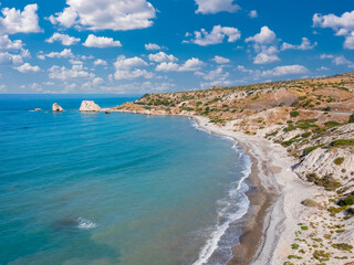 Fototapeta premium Cyprus island. Stone Of Aphrodite. Petra Tou Romiou seascape. Mediterranean sea view from above. Aphrodite bay with blue sky. Beaches in Cyprus. Coast of Cyprus. Pathos, Kuklia region