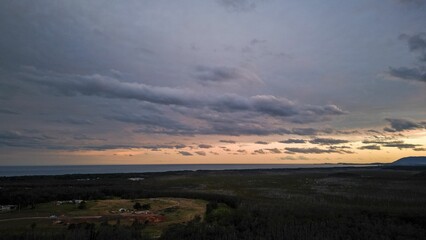 Aerial shot of the forest surrounding the Port Macquarie town at sunset in Australia