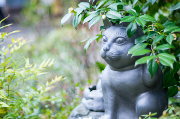 Obraz premium 京都 妙心寺の茂みの中に潜む猫の銅像