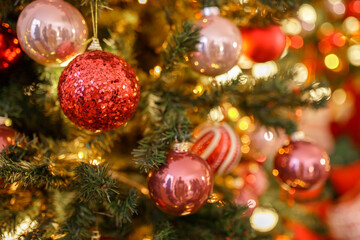 Obraz na płótnie Canvas Close up of balls on christmas tree. Bokeh garlands in the background. New Year concept