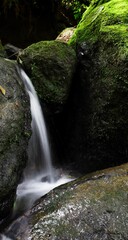 Vertical shot of a waterfall between the rocks
