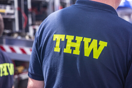 Neuwied, Germany - July 09, 2022: a volunteer of the German "Technisches Hilfswerk" (Federal Agency for Technical Relief) with the sign "THW" on the backside of his shirt