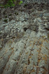 Vertical of a staircase in an old abandoned stone building gainst green trees
