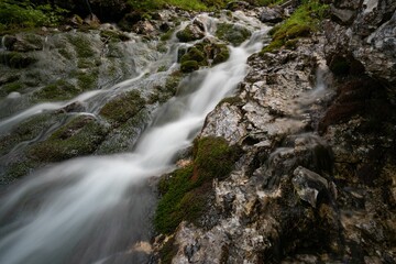 Long exposure shot of a river flowing down the rocks in a forest surrounded by wild nature