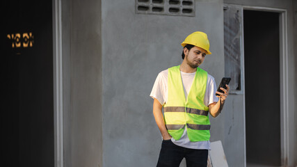 Asian male construction worker using a smartphone