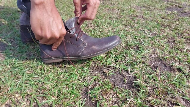 wearing a brown leather shoes, Man tying patent leather shoes
