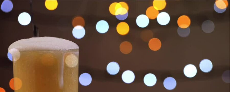 pouring beer into a glass under the sparkling party lights