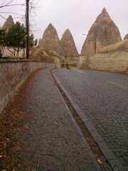 Cappadocia road, traveling among Fairy Chimneys. Street with mountains and rocks, autumn season and falling leaves