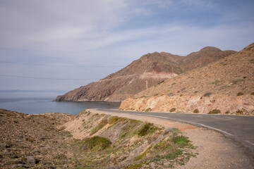 Scenic view of a highway road passing by the beautiful mountains and sea in Cabo de Gata, Spain