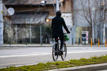 Riding a bicycle on the city streets. Commute to work in Bucharest, Romania, 2022