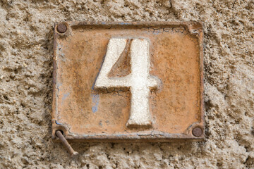 Old retro weathered cast iron plate with number 4 closeup 