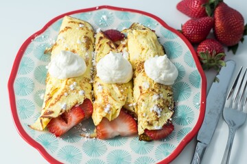 Closeup of strawberry crepes with white cream