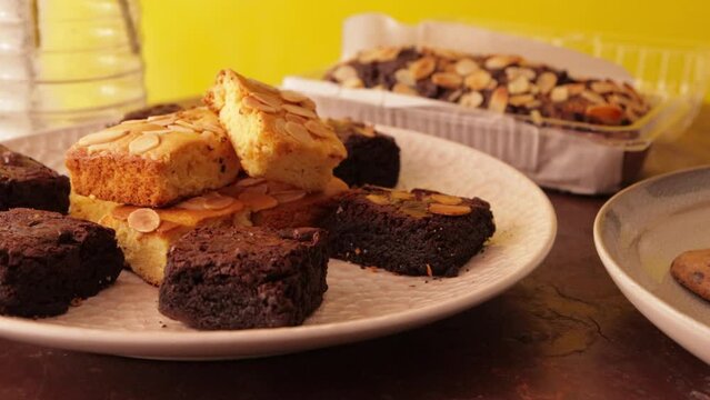 Steady shot of blondies and brownies with banana bread from behind.