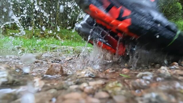 Hiking in the rain in Norway, splashing water from a small stream, jumping into puddle
