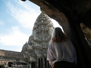 Australian woman with blonde hair exploring old historical ruins in daylight in Cambodia