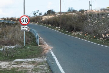 Paved road with a road sign prohibiting the movement of vehicles and motorcycles