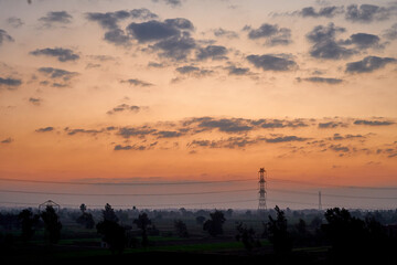 The blue sky is orange and the clouds are soft when the sun is about to set.