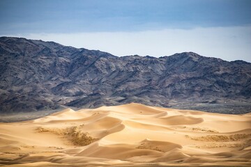 Mesmerizing view of the sandy desert,on a sunny day with a blue sky and dune,drift in the background