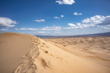 Mesmerizing view of the dunes in the desert, on a bright sunny day with blue sky and fluffy clouds