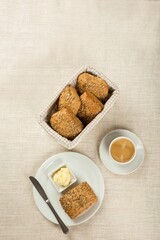 Vertical top view of a simple breakfast with butter, bread, and a cup of coffee