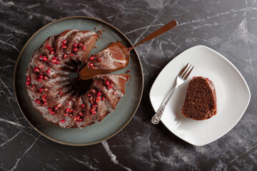 Top view of mulled wine sponge cake with icing and pomegranate seeds.