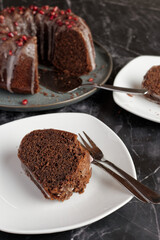 Mulled wine sponge cake with icing and pomegranate seeds.