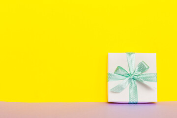 holiday handmade white present tied green ribbon bow top view with copy space. Flat lay holiday background. Birthday or christmas present. Christmas gift box concept with copy space