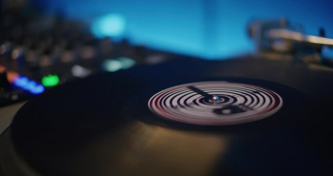 Closeup view of DJ hands playing music on turntable during event