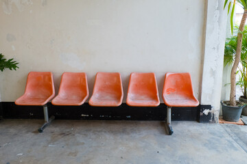 Fototapeta na wymiar Orange plastic chairs at the bus stop.