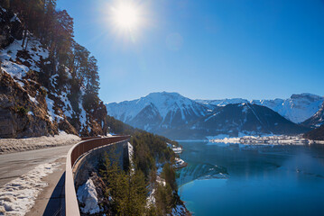 lakeside road Achensee in winter, bright sunshine, mountain view Tirol