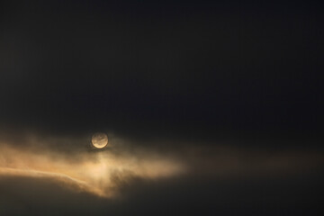 Luna llena iluminada rodeada por nubes en la noche
