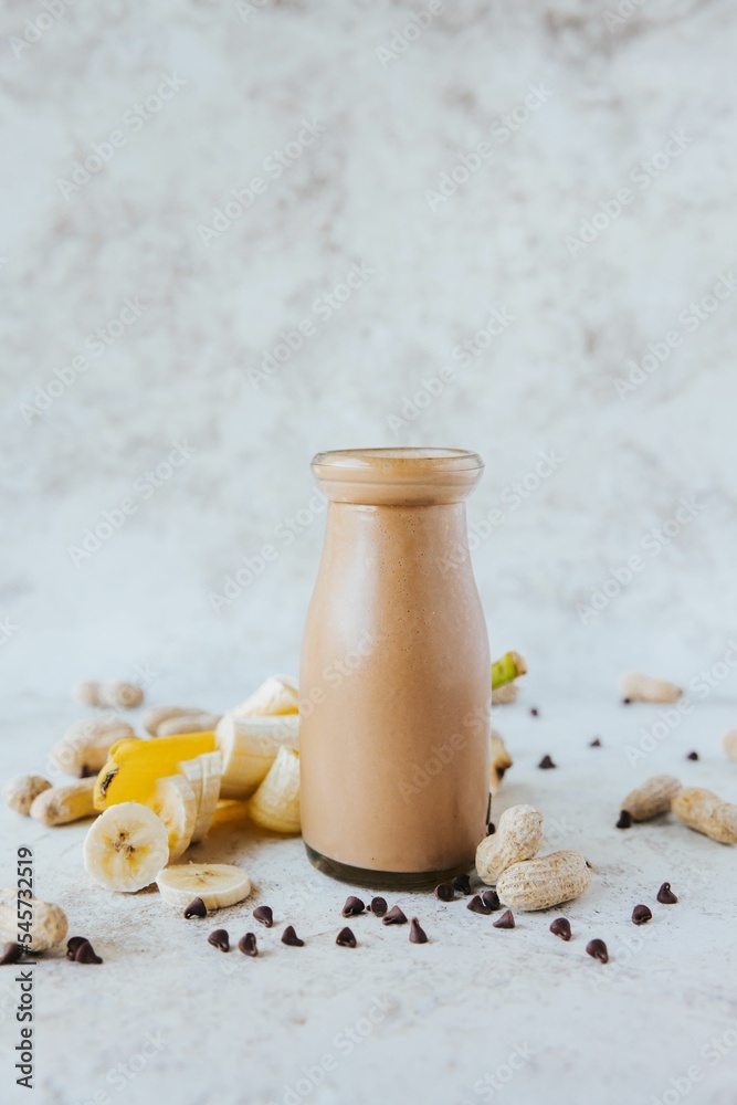 Sticker Vertical shot of a banana milkshake with butter and peanuts