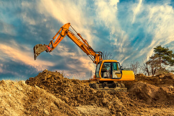 Crawler excavator during earthmoving works on construction site at sunset © EdVal