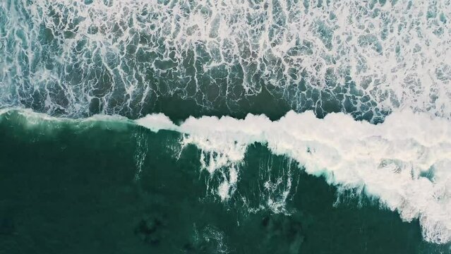 Aerial view of green ocean waves coming onto the shore at Big Sur, California