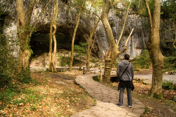 Fototapeta na wymiar Adult hiker on the stone path in Zugarramurdi witches cave in Navarre, Spain.
