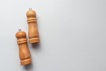 salt and pepper wooden shakers, grinders on a white table with white background