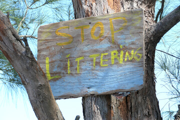Stop Littering sign nailed to tree