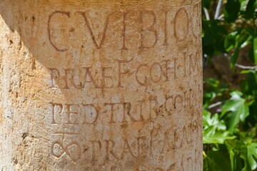 Closeup of an ancient Greek inscriptions on the pillar of the Roman city of Gerasa in Jerash, Jordan