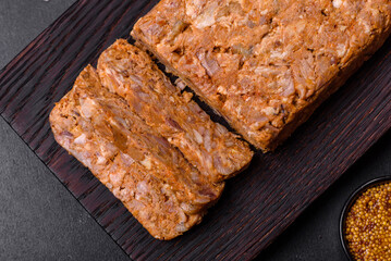 Tasty meat brawn or roll on a wooden cutting board with spices and herbs