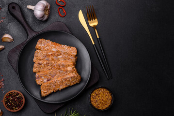 Tasty meat brawn or roll on a wooden cutting board with spices and herbs
