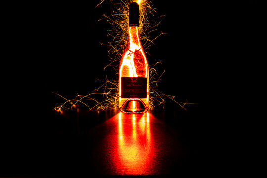 Sansibar sparkling wine with sparklers illuminated with many sparks against a black background