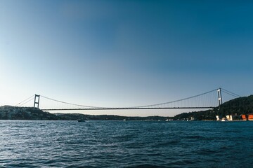 Beautiful view in a distance of Bosphorus bridge in Istanbul over the water under blue sky