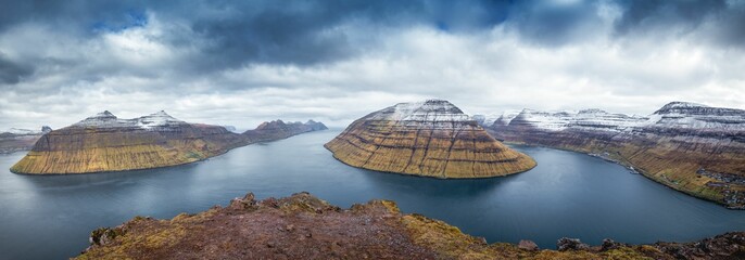 Naklejka premium Panoramic scene of Klakkur Hike in The Faroe Islands with sunset gray gy clouds