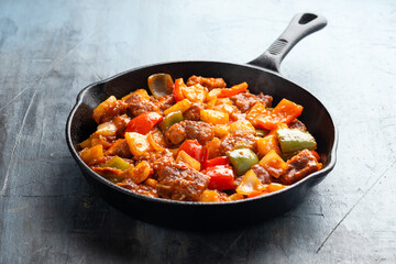 Sweet and Sour Pork with bell pepper, pineapple in iron cast pan