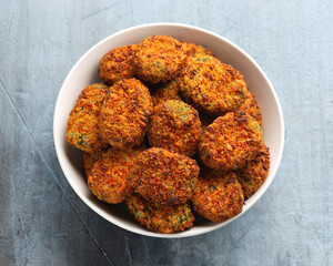 Carrot and spinach vegan vegetarian bites in white bowl, party finger food.