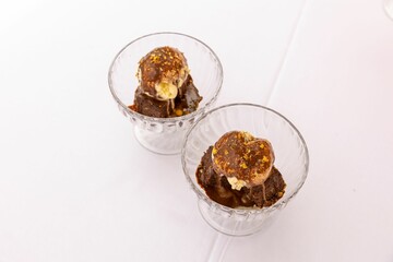 Top closeup of a chocolate dessert in glass, a small bowl on the white background
